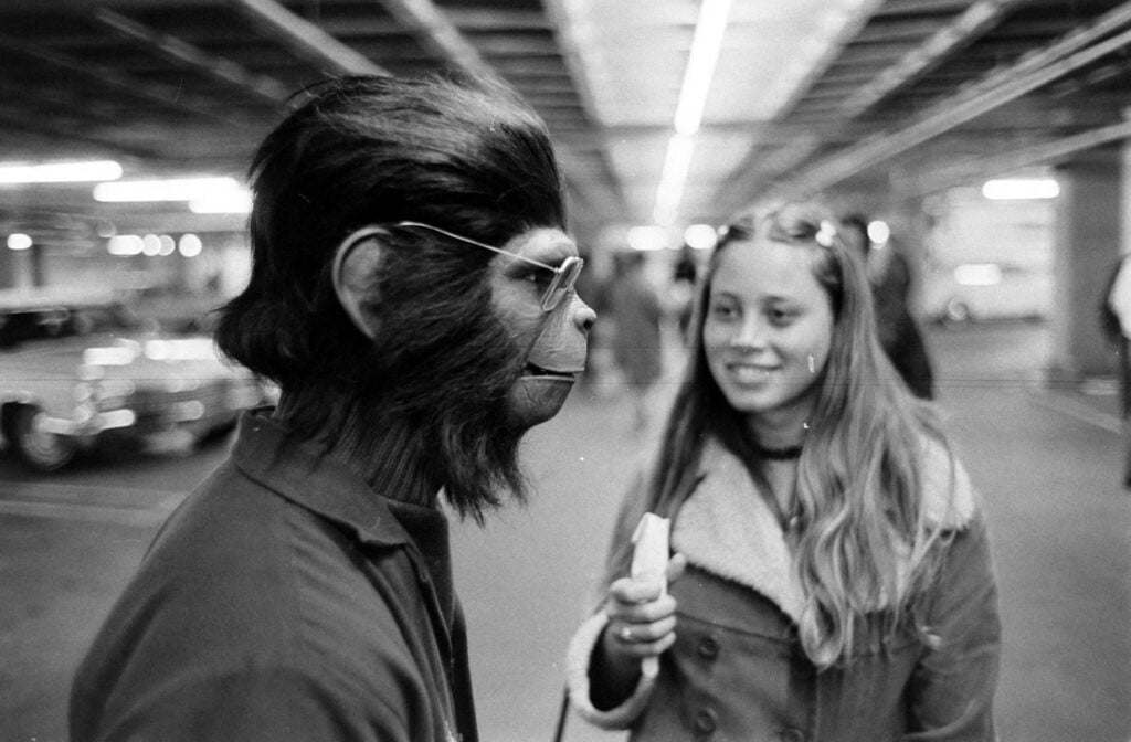 an actor from Planet of the Apes dressed in an ape suit and wearing glasses