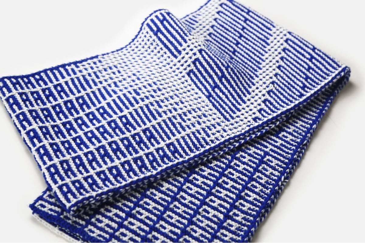 a blue patterned scarf with the repeated letter A