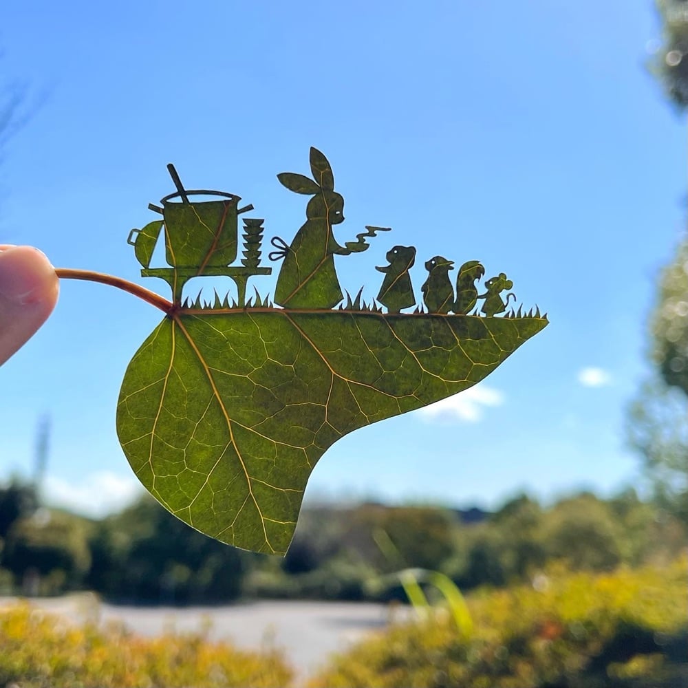 leaf cutout art of a rabbit offering hot soup to other animals