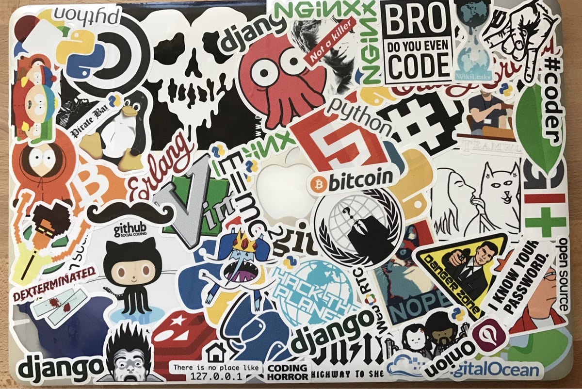 Laptopstickercollage met technische en programmeerreferenties, waaronder GitHub-, Python-, Bitcoin-, Django- en Linux-logo's vermengd met beelden van de internetcultuur.