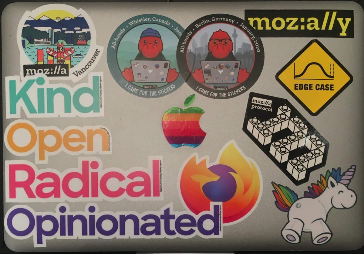 Laptop stickers displaying Mozilla branding, vintage Apple logo, Firefox logo, and various tech company logos arranged on a light gray background.
