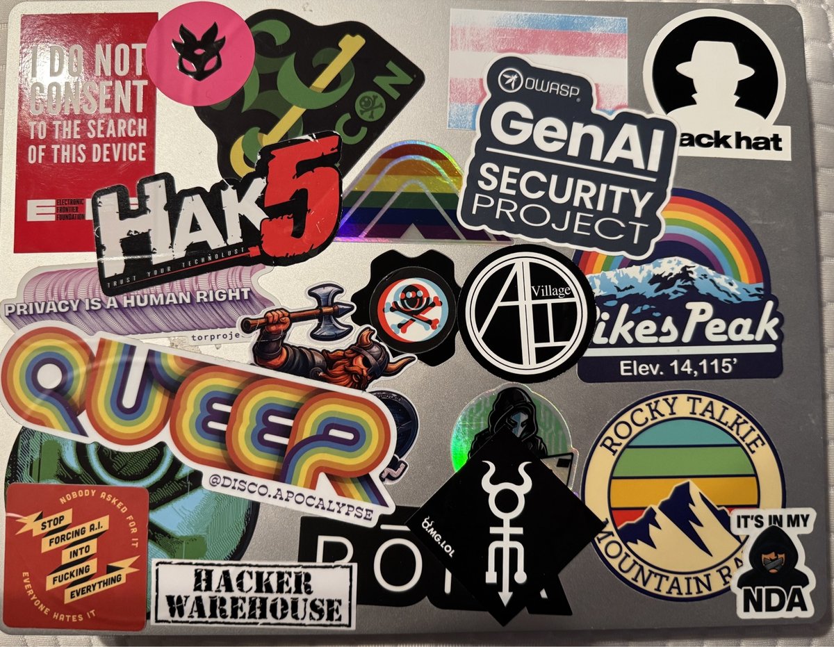 Laptop bedekt met cyberbeveiligings-, hacking- en activistische stickers, waaronder OWASP, Hack5, logo's met bergthema en anti-surveillanceberichten.