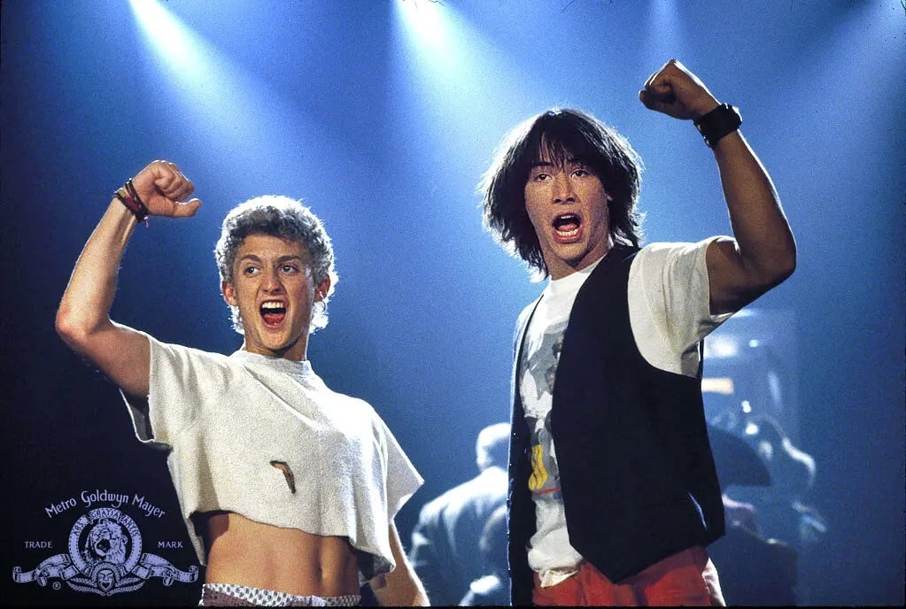 two happy young men raise a fist in the air