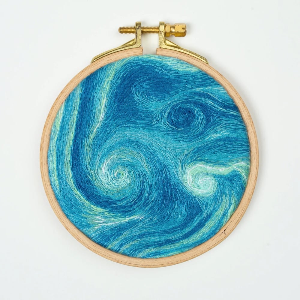 hand-embroidered artwork of a satellite view of Earth