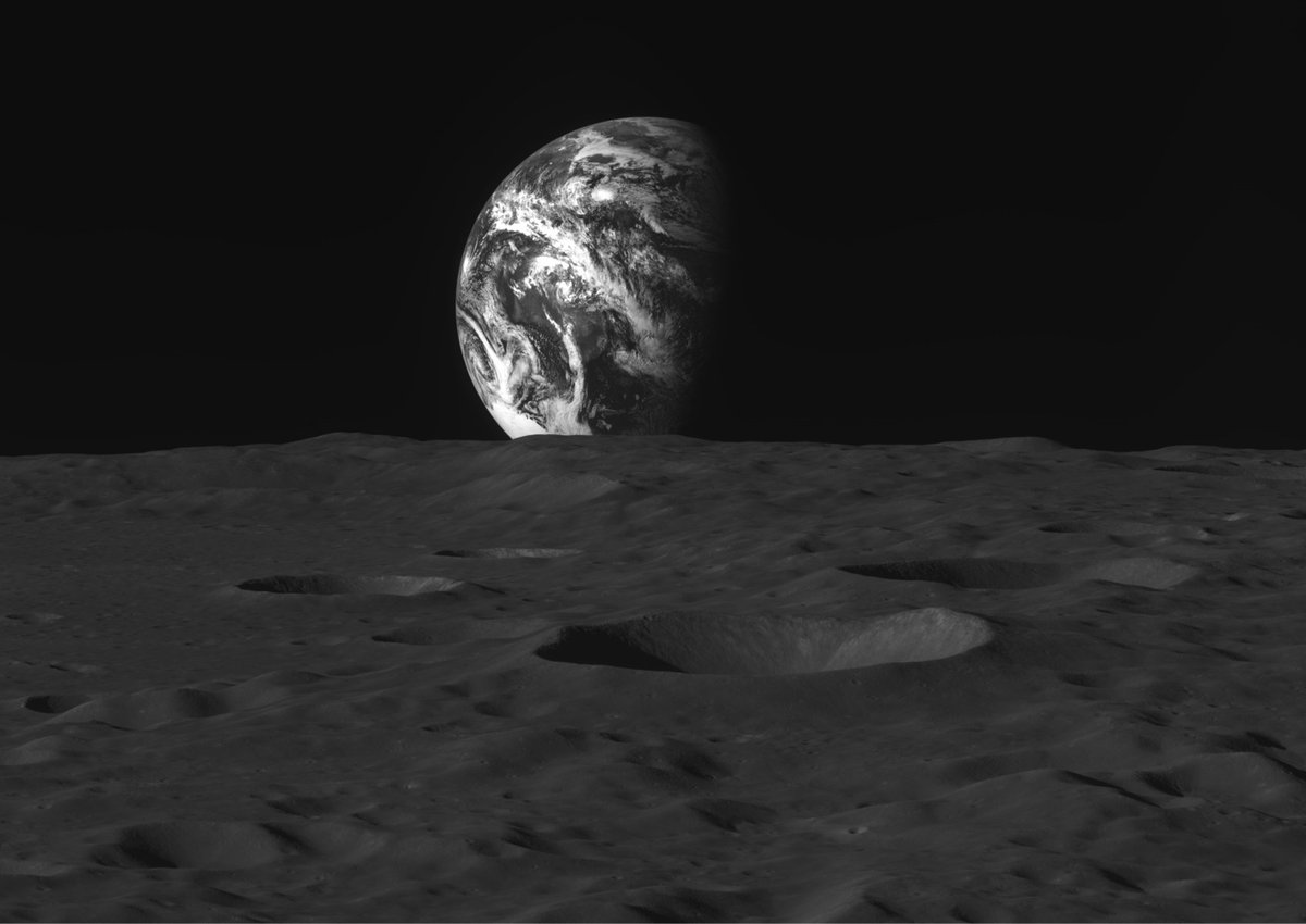 black and white photo of the Earth rising over the surface of the Moon