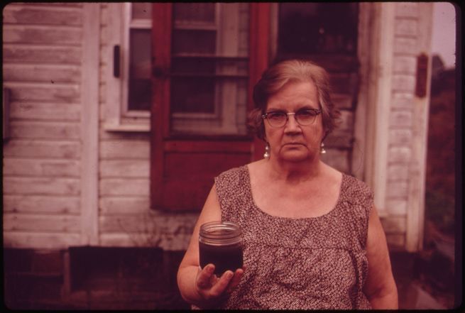 erik_calonius_-_mary_workman_holds_a_jar_of_undrinkable_water_that_comes_from_her_well_and_has_filed_a_damage_suit_against_the_hanna_coal_company_._101973.jpg