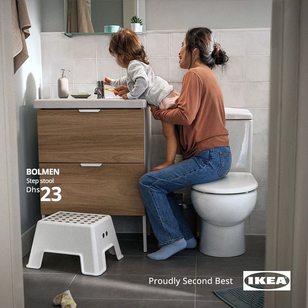 an Ikea ad with a kid standing on their mom to reach the sink instead of using a nearby step stool