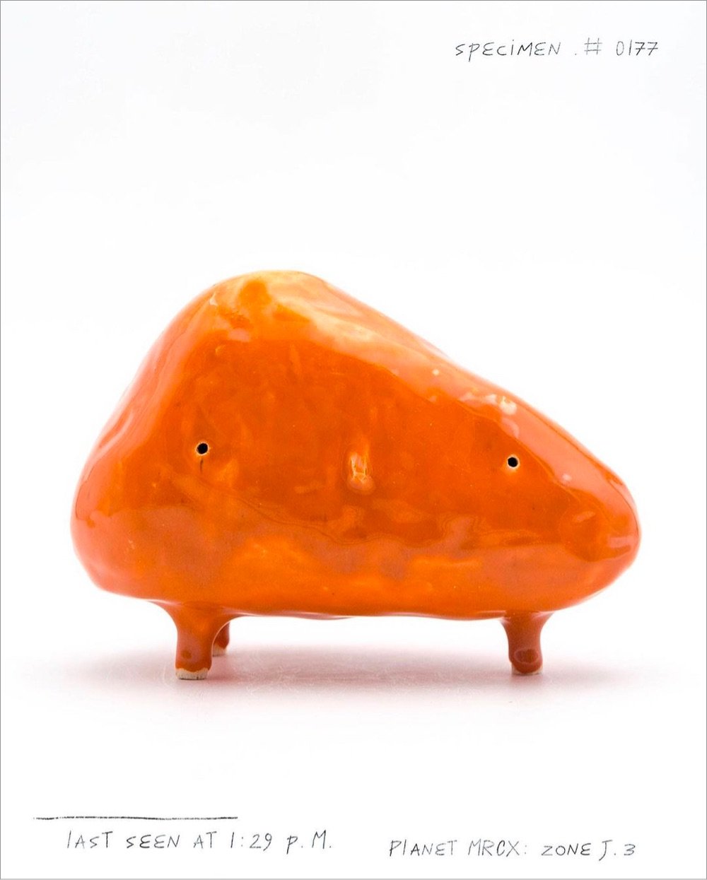 an orange ceramic alien shaped like a triangle
