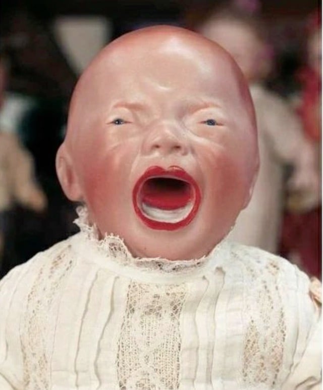 a creepy looking screaming doll