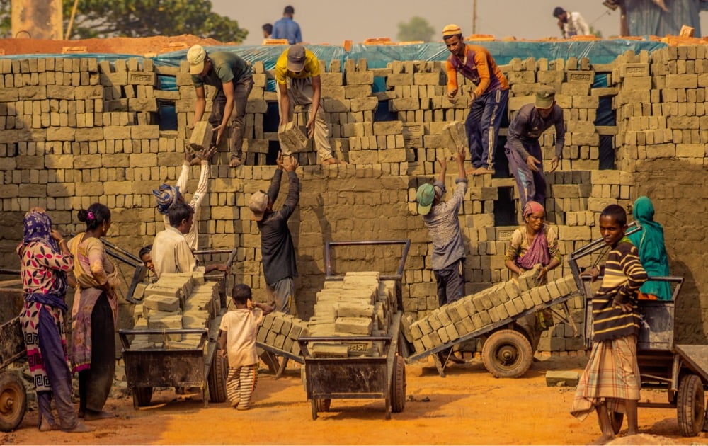 several people work to build a brick wall