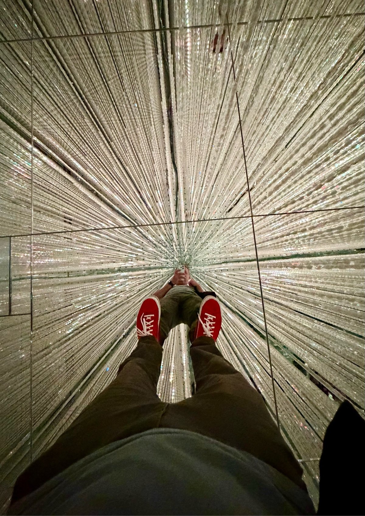 photo of a person standing in a mirrored room with lights all over