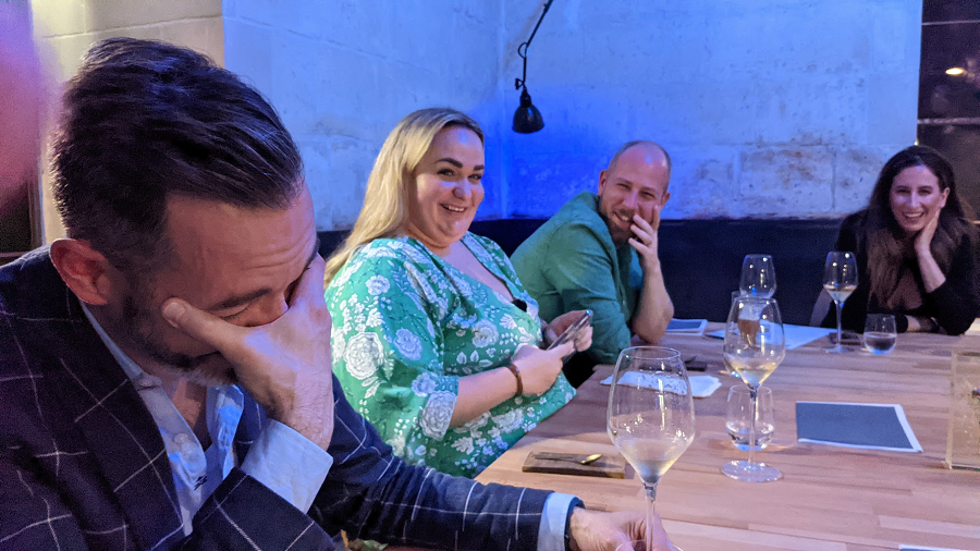 Four people laughing and befuddled at a terrible meal