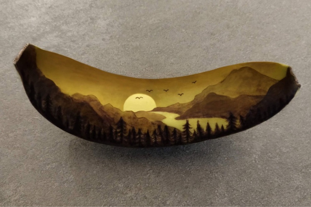 art of a sunset over a river imprinted on a banana