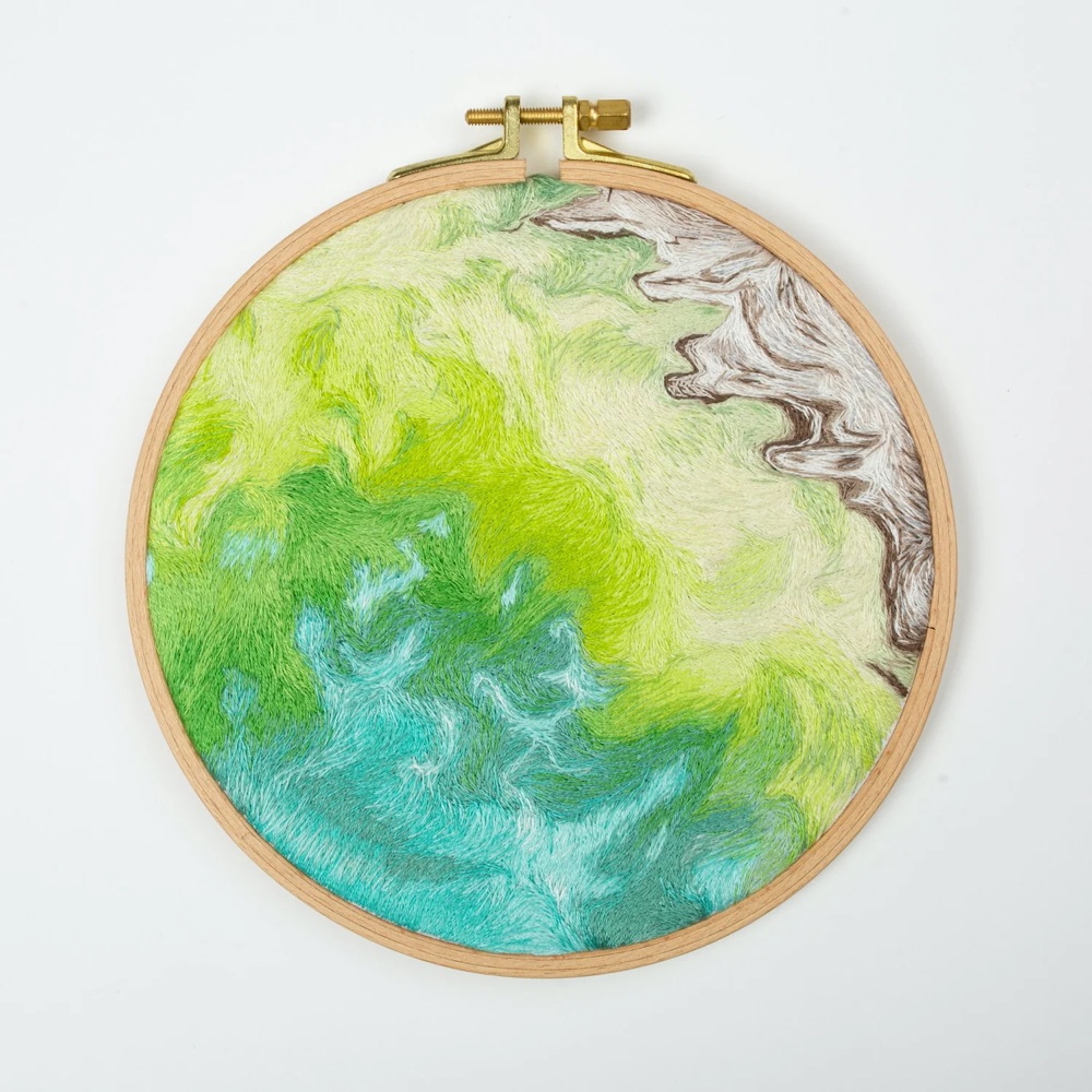 hand-embroidered artwork of a satellite view of Earth