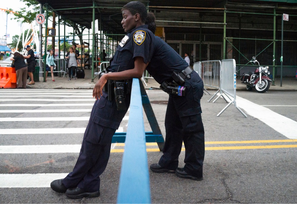 two police officers leaning on a barricade