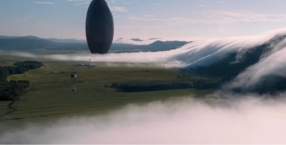 an alien ship hovers in a foggy valley