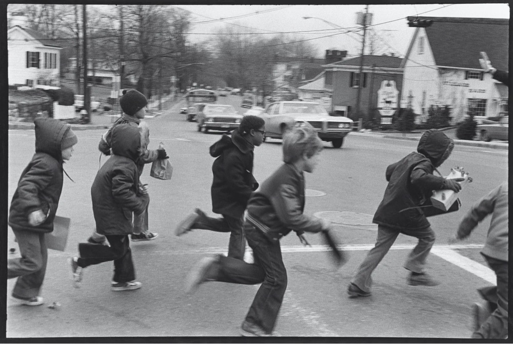 black and white photo of kids running across the street in 70s New Jersey