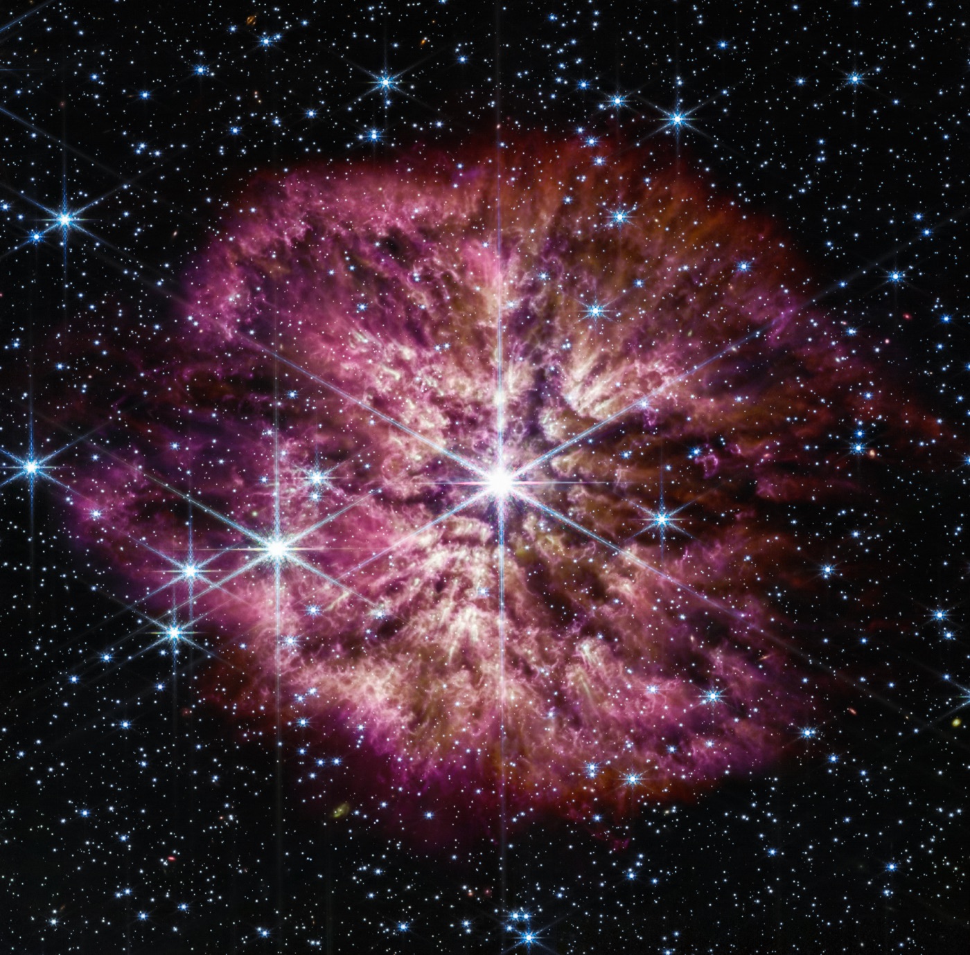 The luminous, hot star Wolf-Rayet 124 (WR 124) is prominent at the center of the James Webb Space Telescope's composite image combining near-infrared and mid-infrared wavelengths of light from Webb's Near-Infrared Camera and Mid-Infrared Instrument
