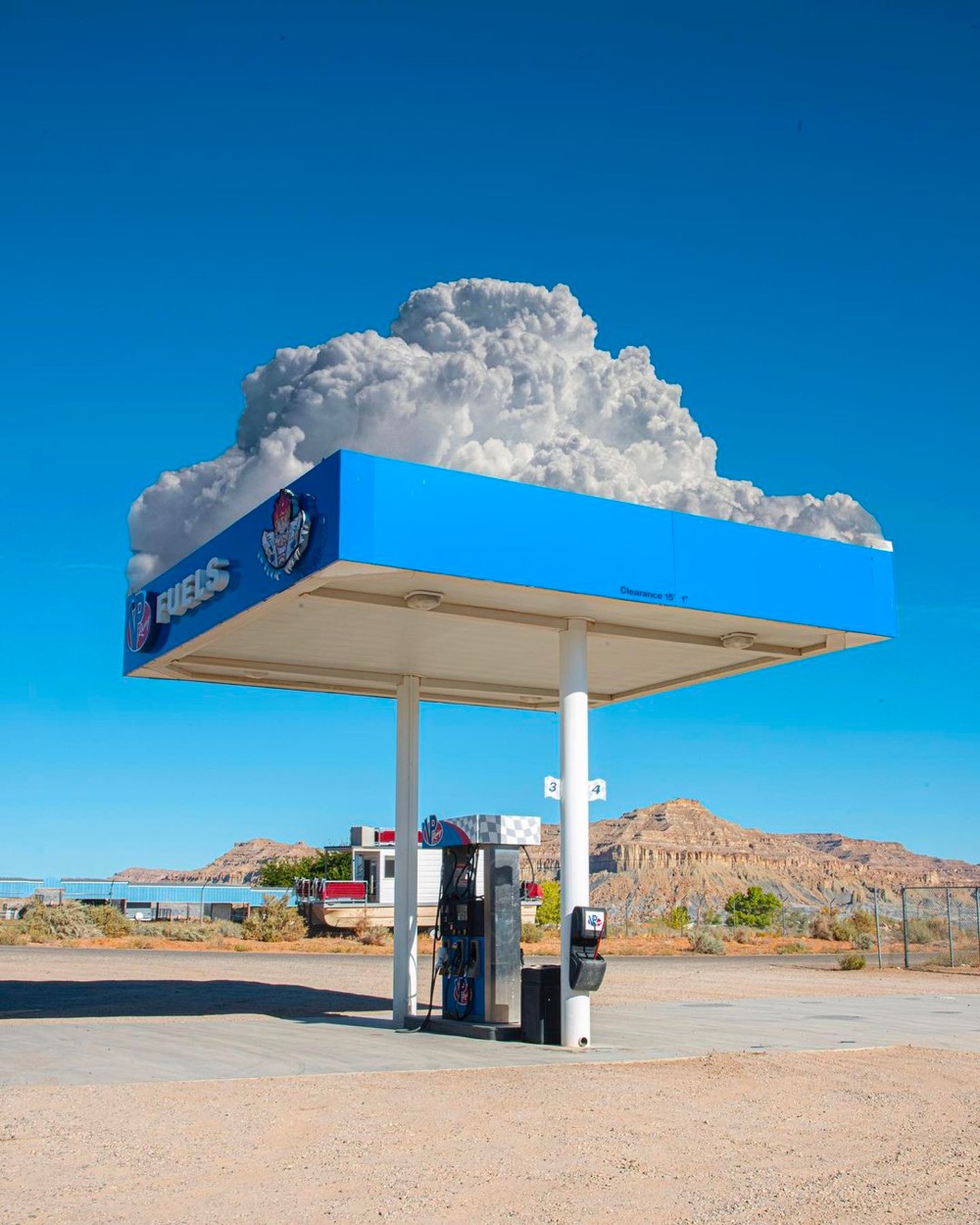 clouds appear to come out of the top of a gas station canopy