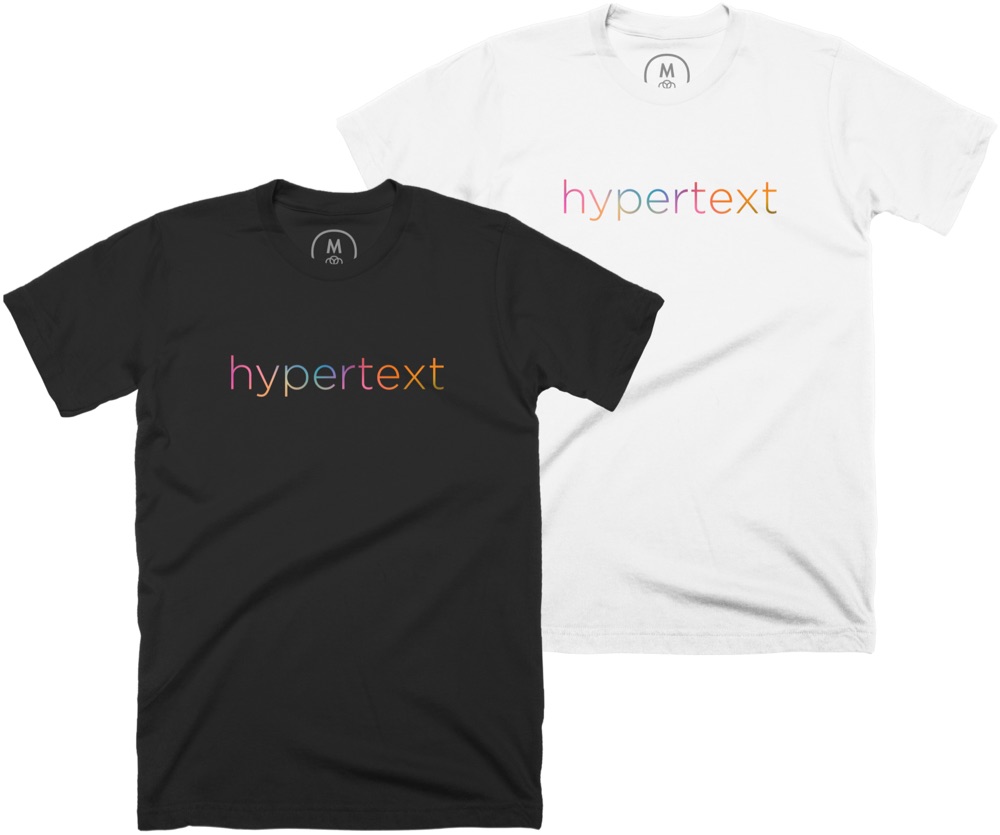 two kottke.org shirts, one black and one white, with a bright multi-colored 'hypertext' printed on them