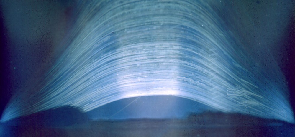 a long exposure photo taken of the path of the sun through the sky using a beer can pinhole camera