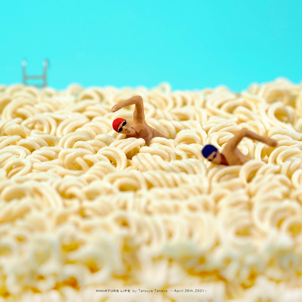 two tiny men swimming in ramen noodles