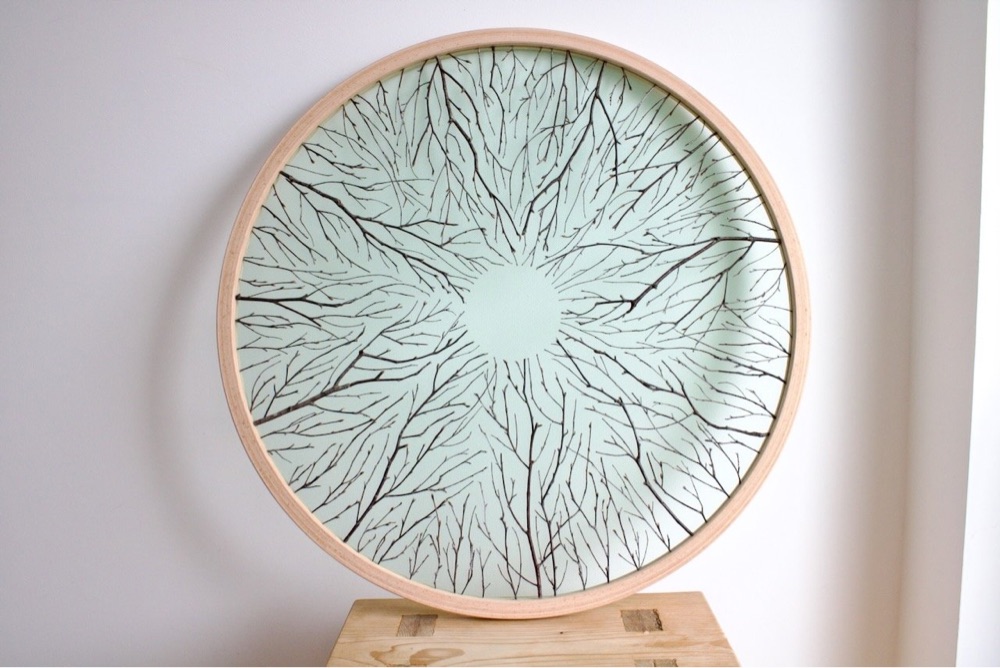 branches arrnaged in a circular pattern on an embroidery hoop