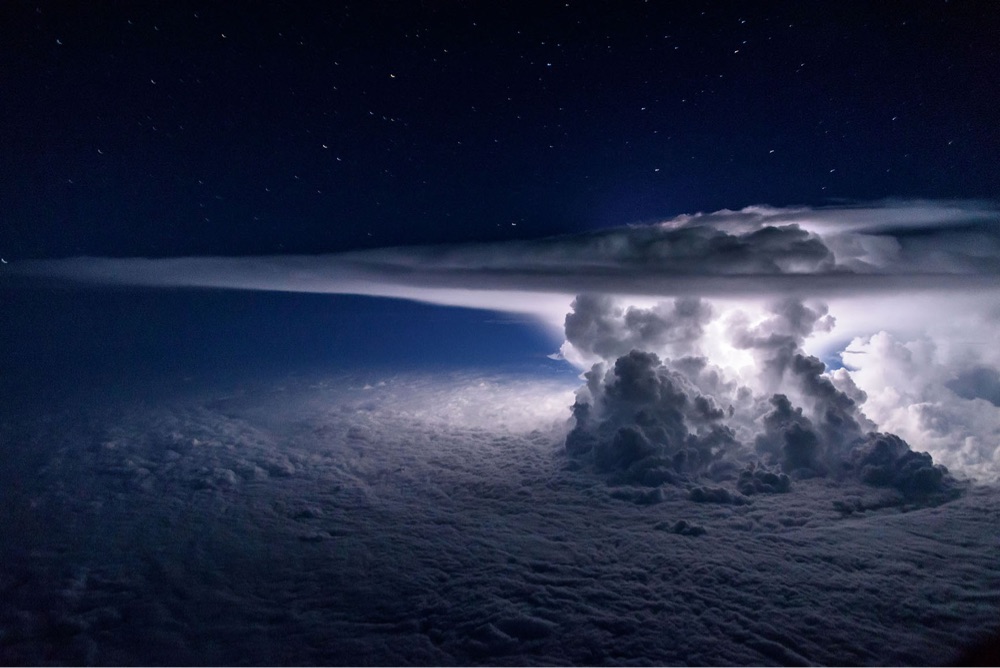 photo of a storm cloud lit up by lightning