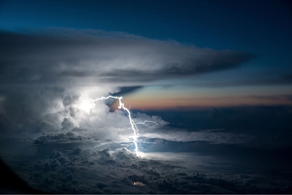 photo of a dramatic bolt of lightning emerging from a storm cloud