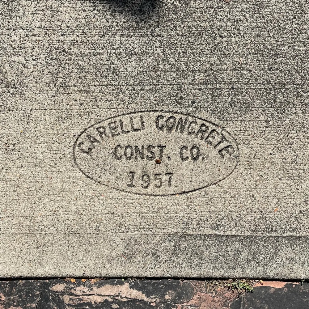 a sidewalk stamps that reads 'Carelli Concrete Const. Co. 1957'