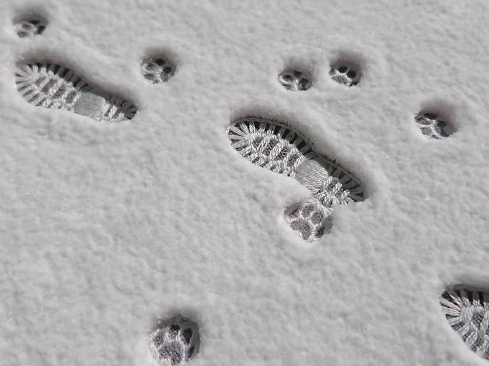 detail of an embroidery that looks like footsteps in the snow