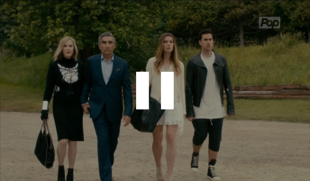 a screencap of the cast of Schitt's Creek walking with a pause symbol over it