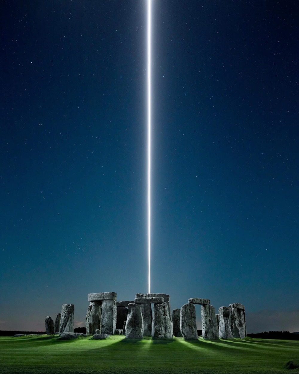a photo of Stonehenge with a blue light shooting out of the middle of it up to the sky
