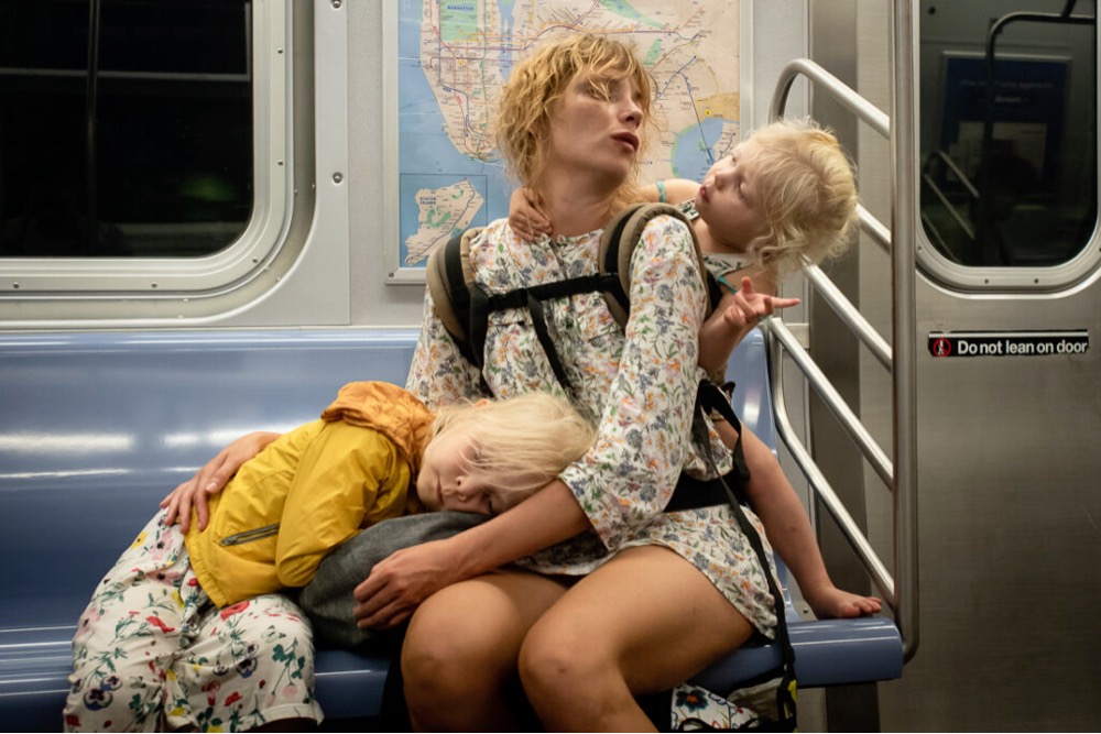 a woman on the subway with two children