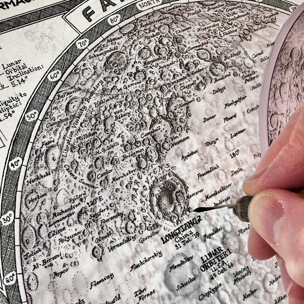 a hand drawing a black and white map of the Moon